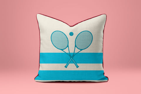 A white and blue striped pillow with a graphic of two crossed tennis rackets.