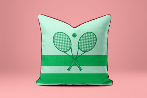 A green and white striped pillow with a graphic of two crossed tennis rackets.