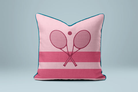 A pink and teal throw pillow with a graphic of two crossed tennis rackets.