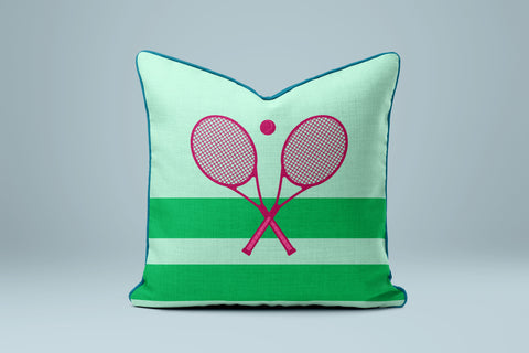 A green and white striped pillow with a pink tennis racket design on it.