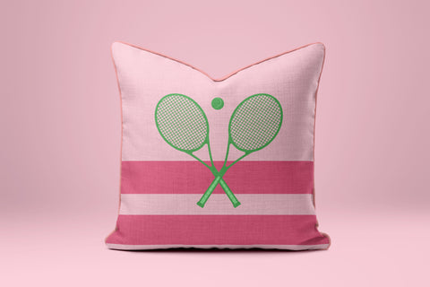 A pink and white striped pillow with a graphic of two crossed tennis rackets on it.
