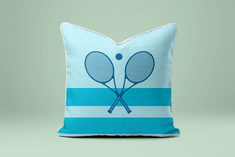 A light blue and white striped pillow with a graphic of two crossed tennis rackets.