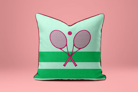 A green and white striped pillow with a pink tennis racket design on it.