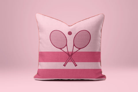 A pink and white striped pillow with a graphic of two crossed tennis rackets.