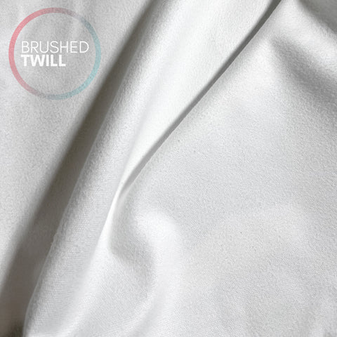 The image is a close-up of a white fabric, possibly a piece of clothing or a textile.