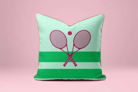 A green and white striped pillow with a pink tennis racket design on it.