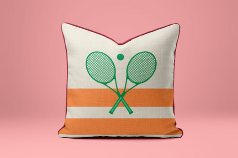 A white and orange striped pillow with a graphic of two crossed tennis rackets on it.