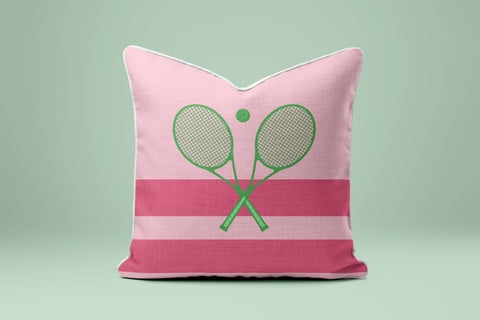 A pink and green striped pillow with a tennis racket design on it.