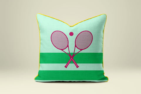 A green and yellow throw pillow with a pink tennis racket design on it.
